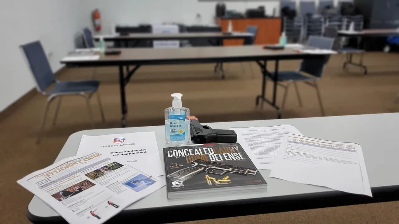 Course materials, registration forms, and a training handbook laid out on a classroom table