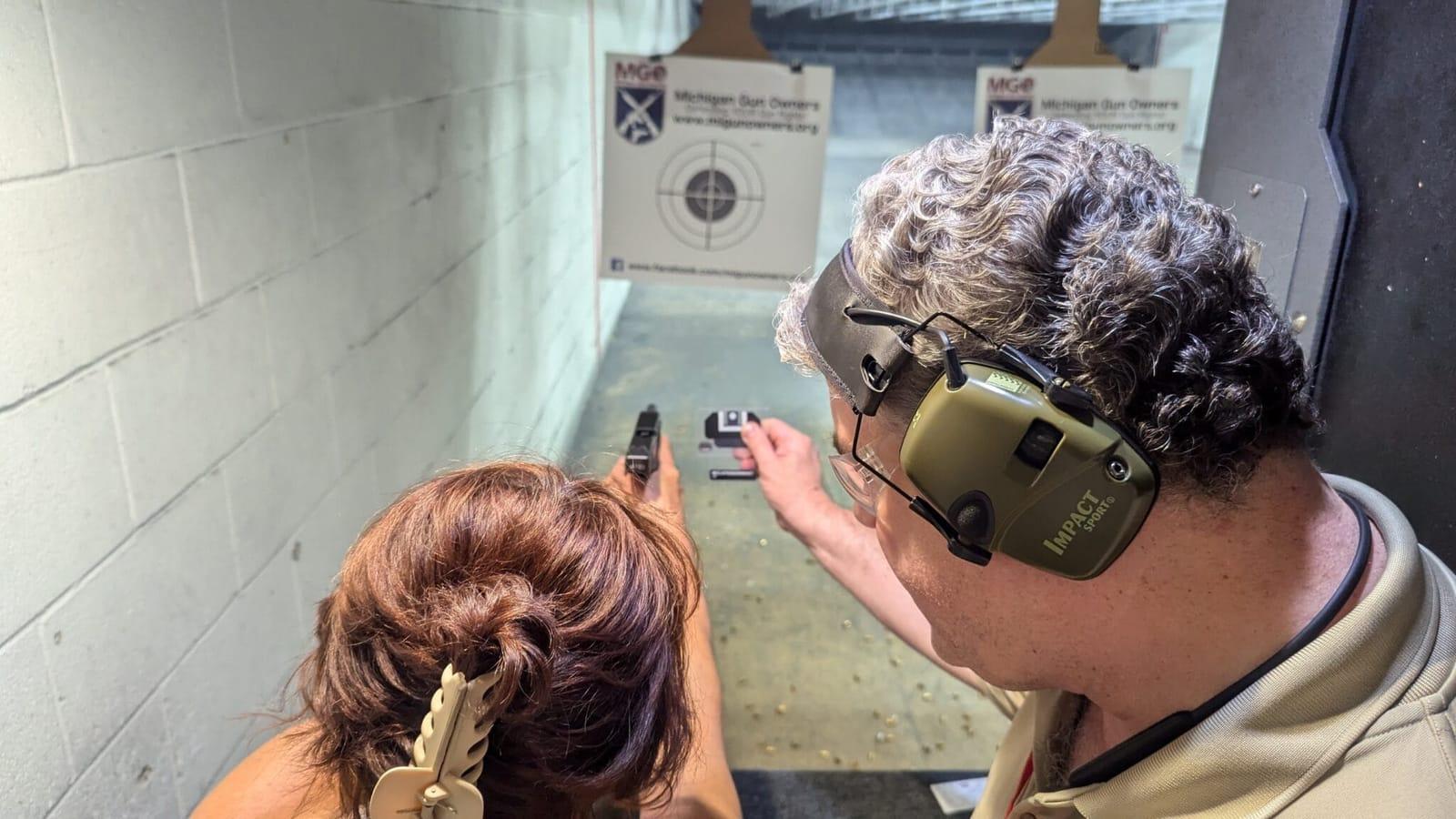 An instructor walking a student through her shots at the firing line