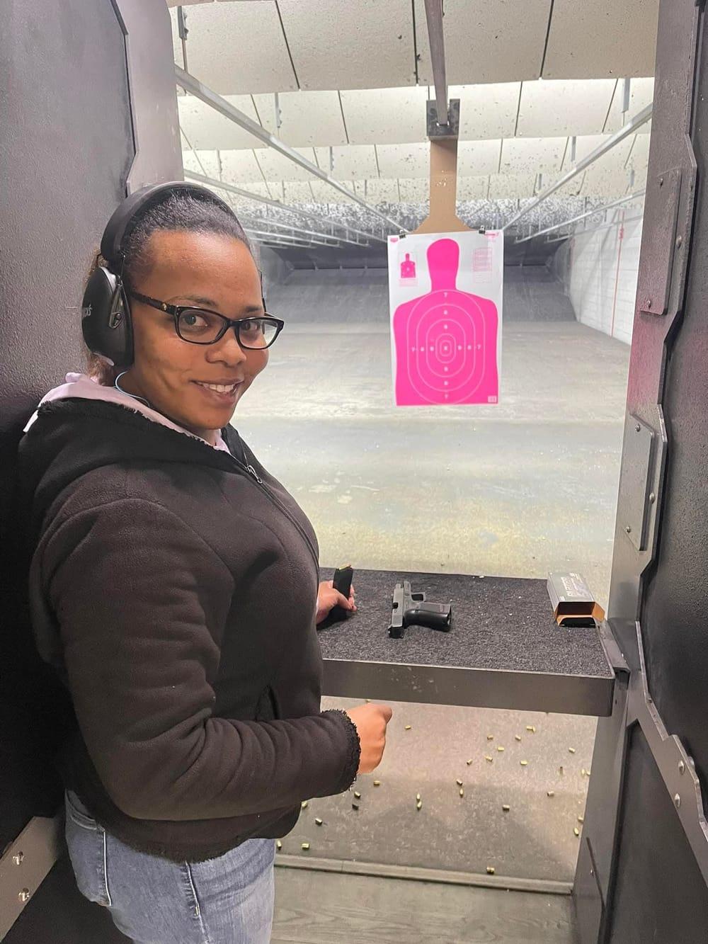 An attendee smiling at her lane after her first shots at the pink target
