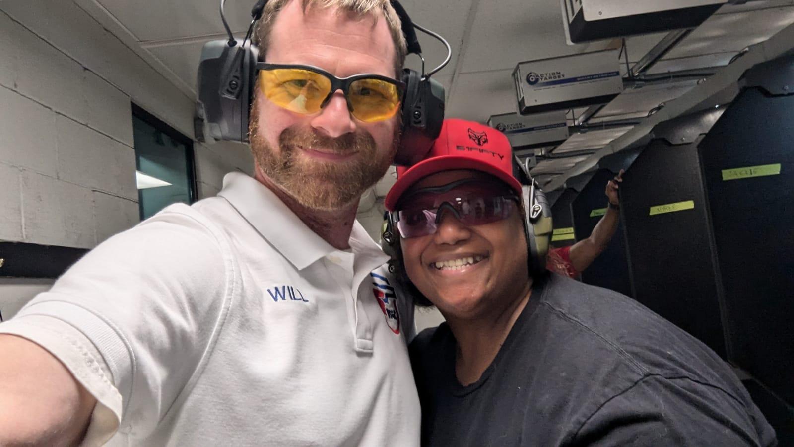 A smiling attendee with her instructor after firing her first rounds