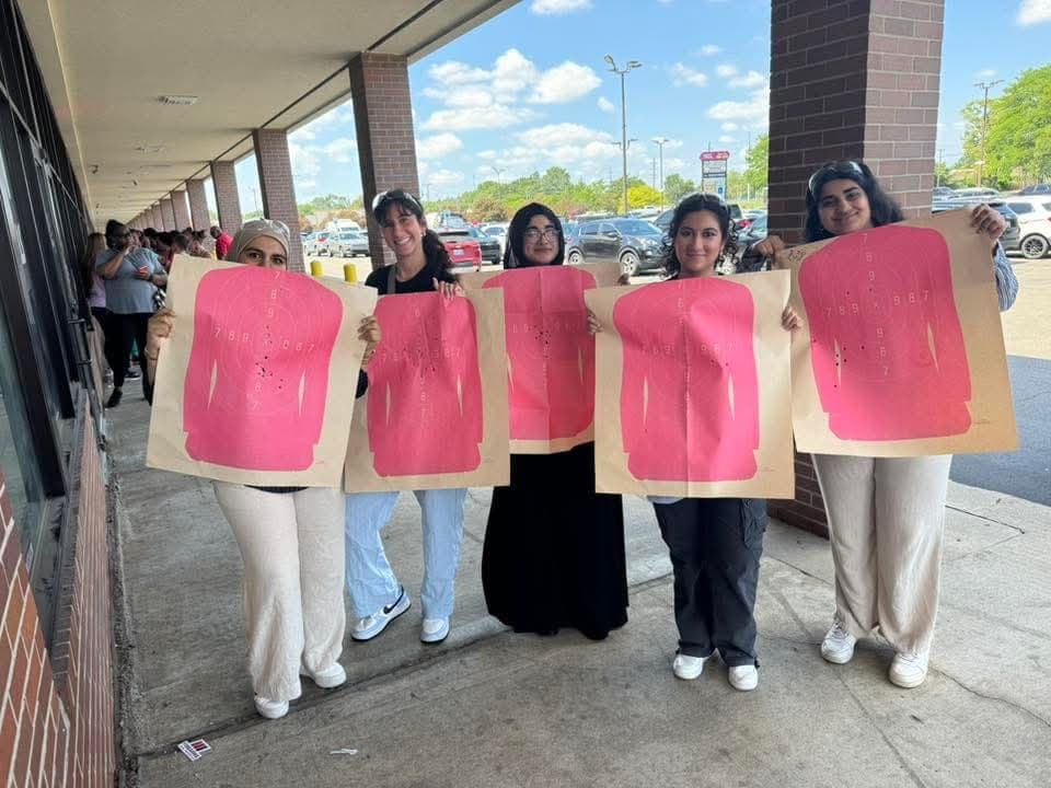 Five women outside the range holding up the first targets they ever shot