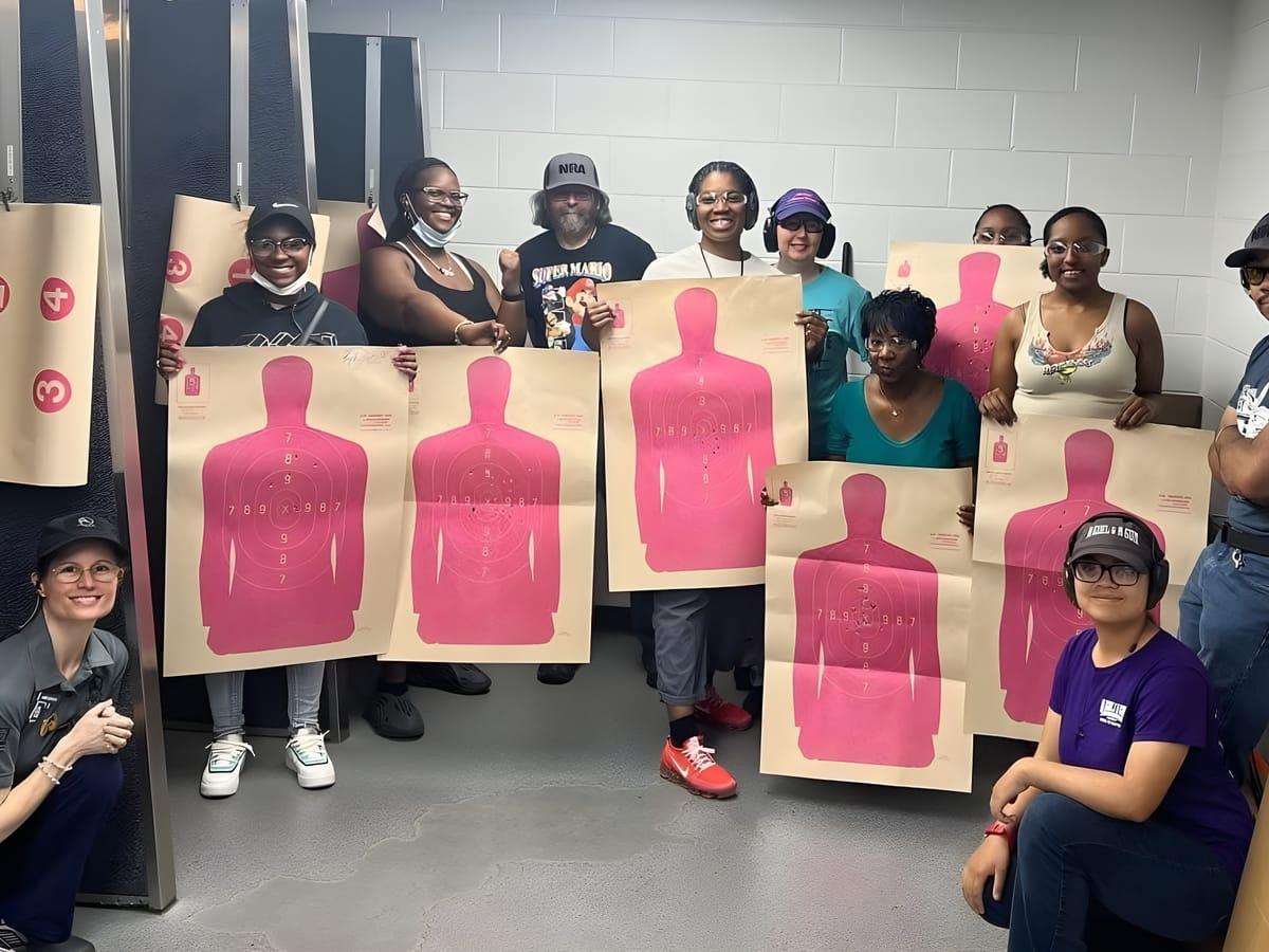 Students holding up the paper targets they shot in their first range session at Ladies Day 2026