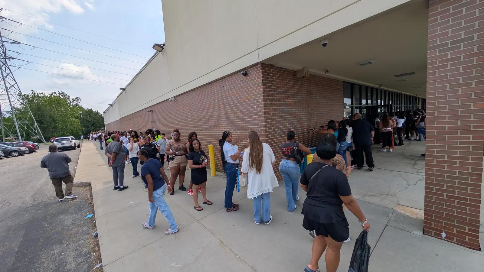 A line of women waiting along the range building on registration morning